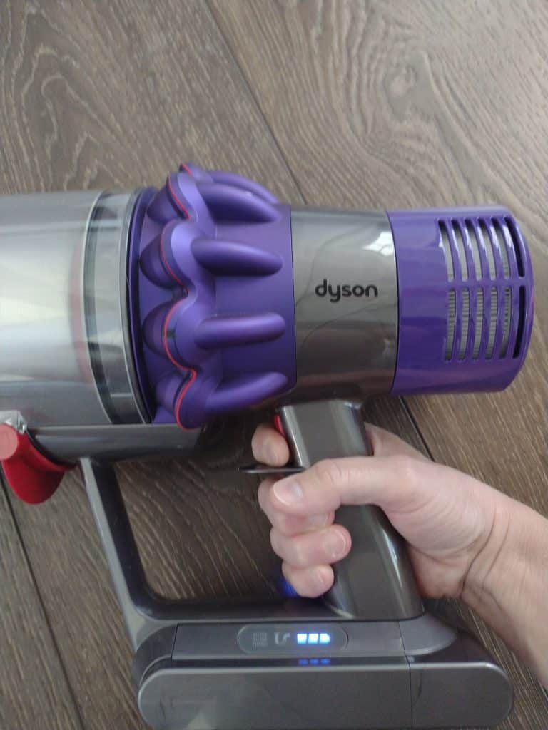 up close of Dyson cyclone V10 pressing the power button